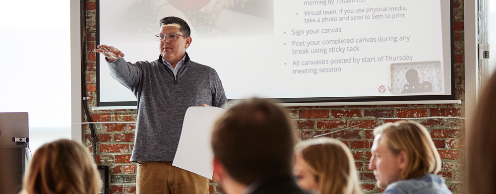 Presenter talking in front of a projector