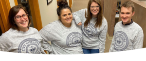 Four people wearing "Civic Nebraska" sweatshirts