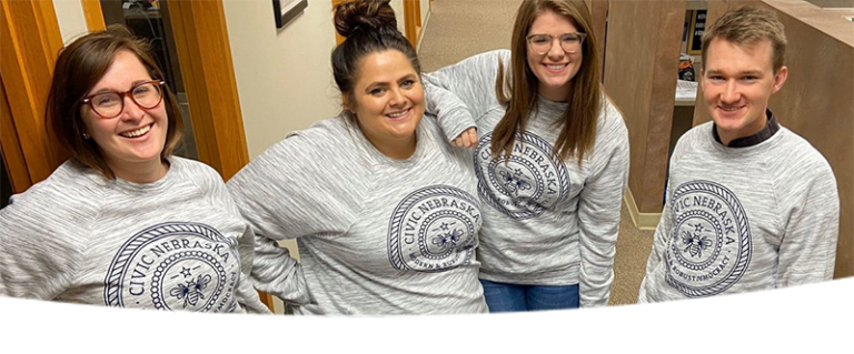 Four people wearing "Civic Nebraska" sweatshirts