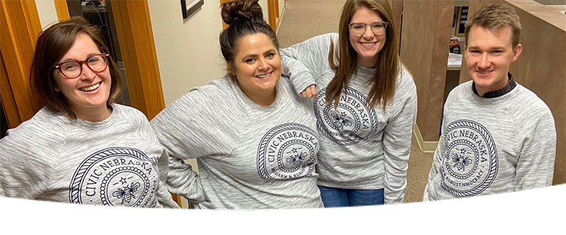 Four people wearing "Civic Nebraska" sweatshirts